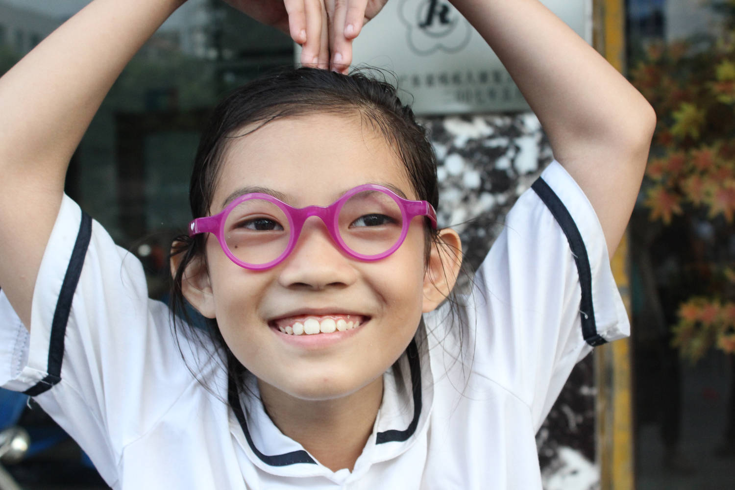 child wears pink adaptive spectacles